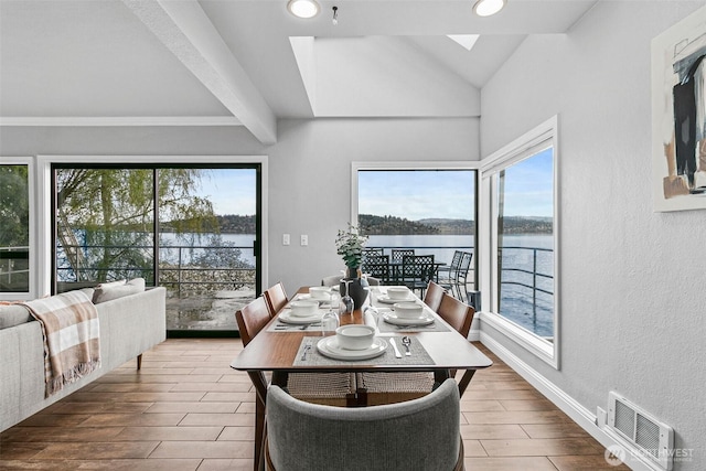dining room with plenty of natural light, visible vents, and a water view
