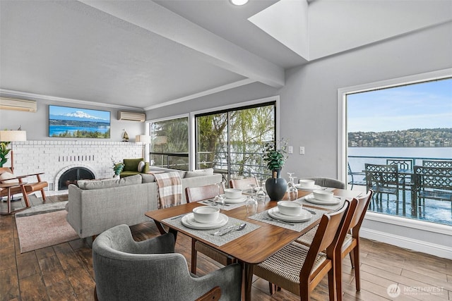 dining space with hardwood / wood-style flooring, a wall mounted AC, and a fireplace