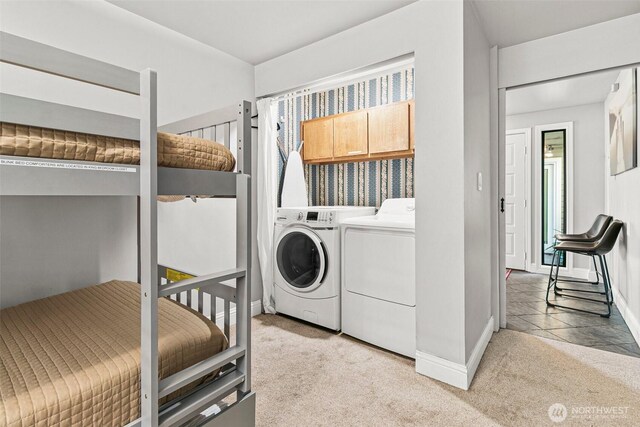 washroom with baseboards, washing machine and clothes dryer, cabinet space, and carpet