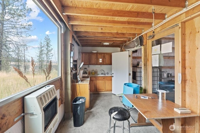 sunroom / solarium featuring a healthy amount of sunlight, heating unit, and a sink