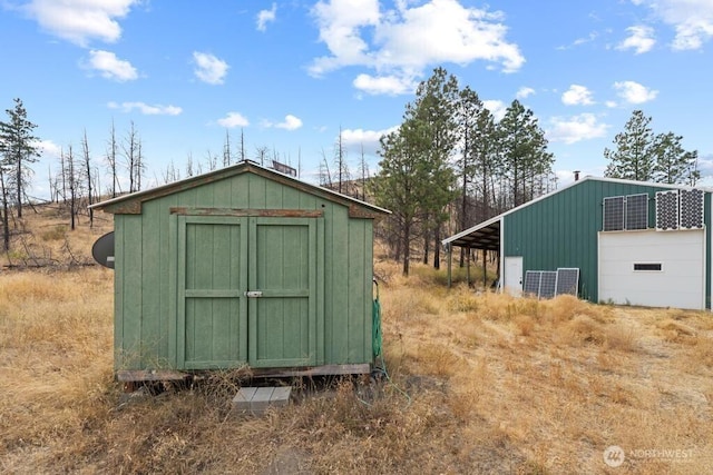 view of outdoor structure featuring driveway and an outbuilding