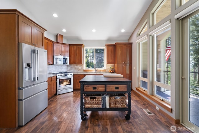27406 NE 65th St, Camas, WA 98607 - kitchen featuring high quality appliances, plenty of natural light, decorative backsplash, dark wood finished floors, and recessed lighting