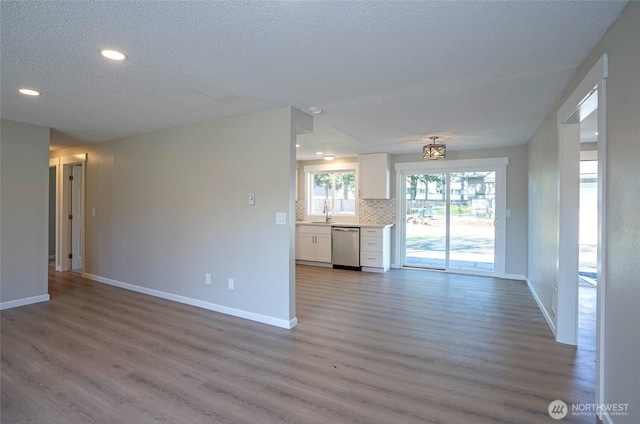 303 Alder Ln N, Pacific, WA 98047 - unfurnished living room with baseboards, recessed lighting, a textured ceiling, a sink, and wood finished floors