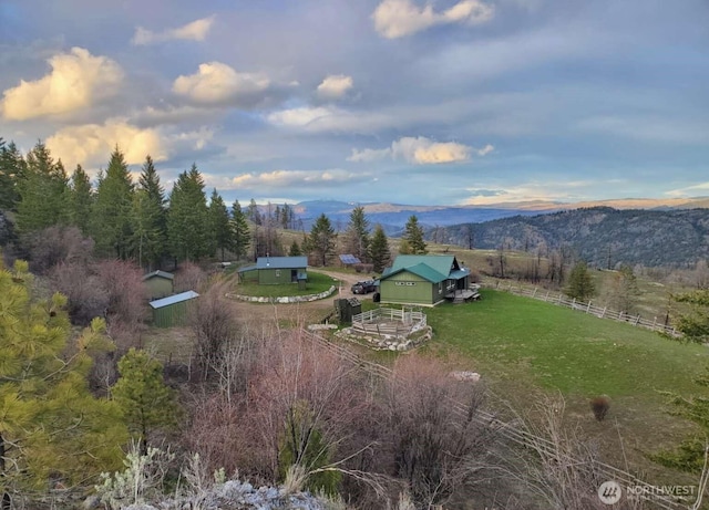 exterior space with fence, a rural view, and a mountain view