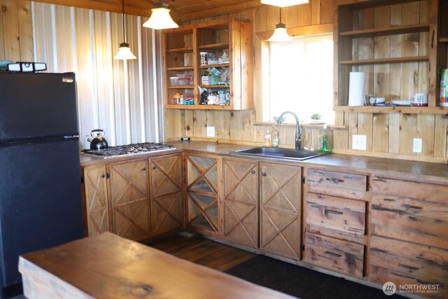 kitchen with open shelves, a sink, stainless steel gas cooktop, dark wood-style floors, and freestanding refrigerator