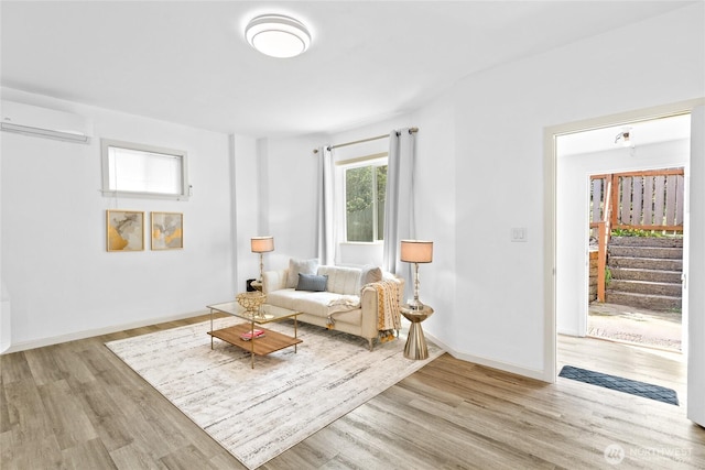 4204 Letitia Ave S, Seattle, WA 98118 - living room featuring stairs, baseboards, a wall unit AC, and light wood-style floors