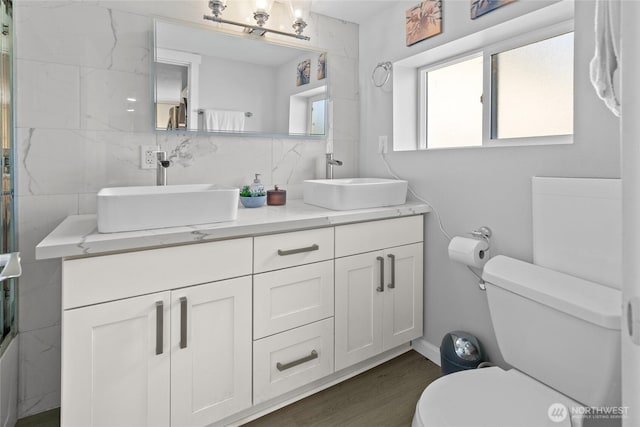 4204 Letitia Ave S, Seattle, WA 98118 - bathroom with a sink, double vanity, toilet, and wood finished floors
