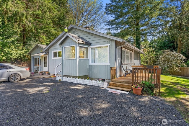 view of front of home with a wooden deck and fence
