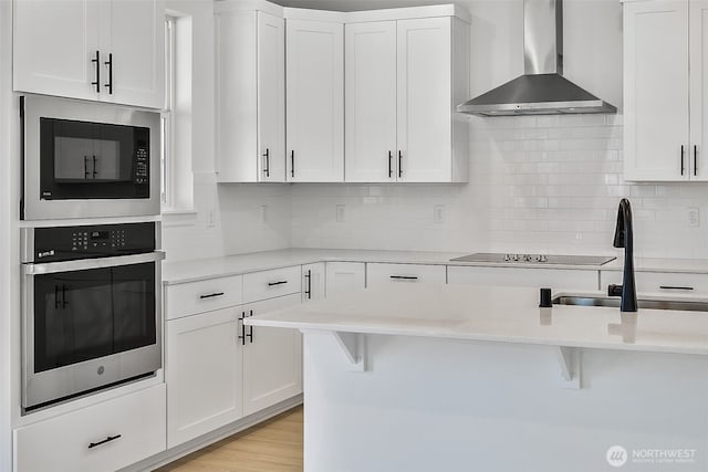 9705 205th St E Unit 29, Graham, WA 98338 - kitchen featuring wall chimney range hood, black electric stovetop, a sink, stainless steel oven, and built in microwave