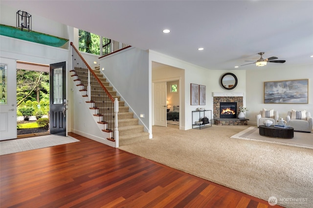 living area with ceiling fan, recessed lighting, wood finished floors, stairs, and baseboards