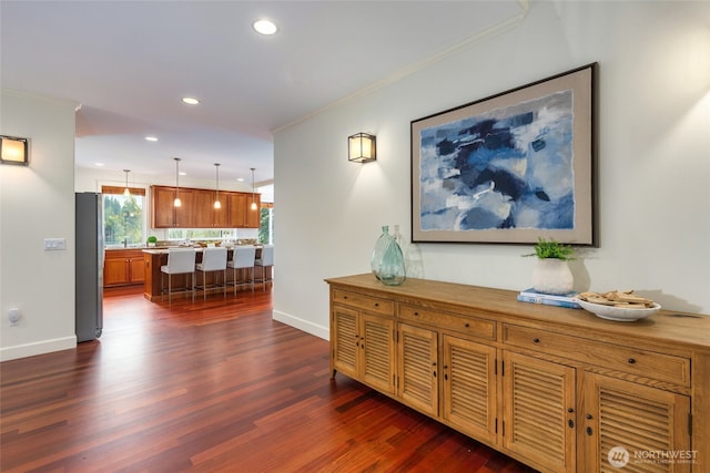 hallway with ornamental molding, baseboards, recessed lighting, and dark wood-style floors