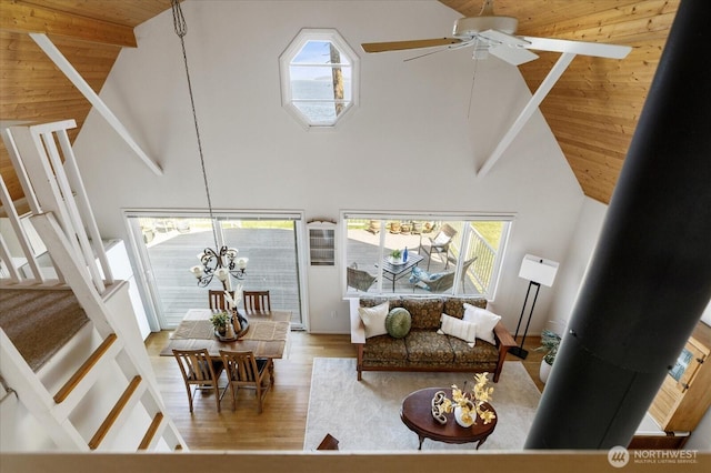 2963 Saratoga Rd, Langley, WA 98260 - living room with ceiling fan with notable chandelier, plenty of natural light, wood finished floors, and high vaulted ceiling