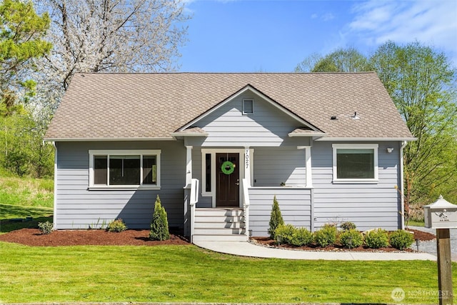 bungalow featuring a porch, a shingled roof, and a front yard