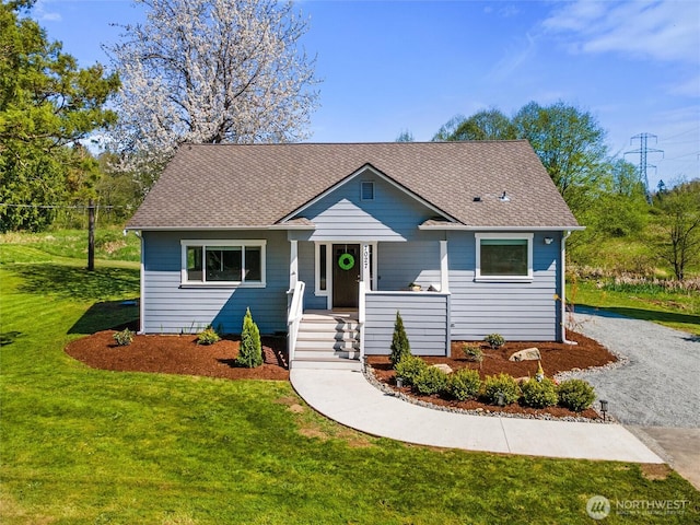 bungalow with roof with shingles, gravel driveway, a front lawn, and covered porch