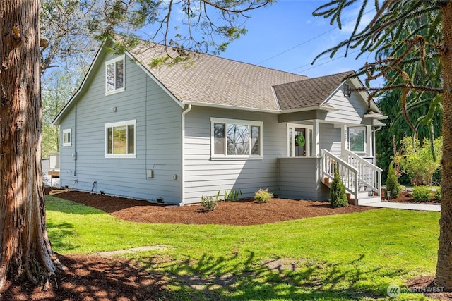 view of side of home with a lawn and roof with shingles