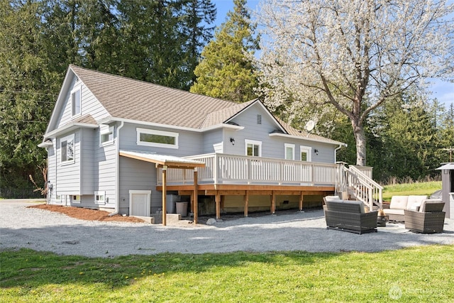 back of property with stairway, outdoor lounge area, a shingled roof, a wooden deck, and a lawn