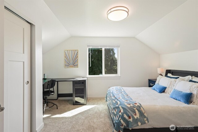bedroom with lofted ceiling, baseboards, and carpet