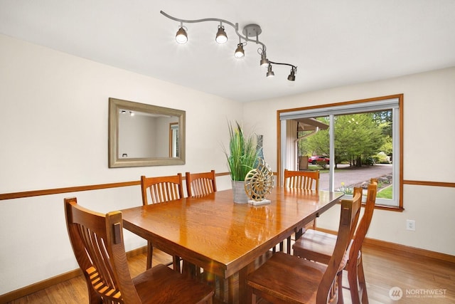 dining area featuring baseboards and light wood finished floors