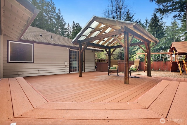 wooden terrace with a playground, fence, and a gazebo