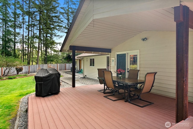 deck with a lawn, area for grilling, a fenced backyard, and outdoor dining space