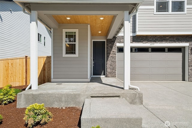 20519 97th Ave E Unit 26, Graham, WA 98338 - doorway to property with stone siding, a garage, and driveway