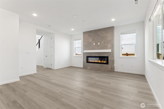 20519 97th Ave E Unit 26, Graham, WA 98338 - unfurnished living room featuring a fireplace, light wood-style floors, recessed lighting, and baseboards