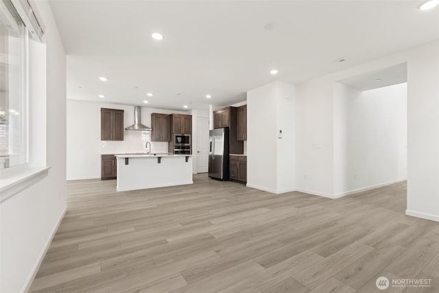 20519 97th Ave E Unit 26, Graham, WA 98338 - unfurnished living room featuring light wood finished floors, recessed lighting, baseboards, and a sink