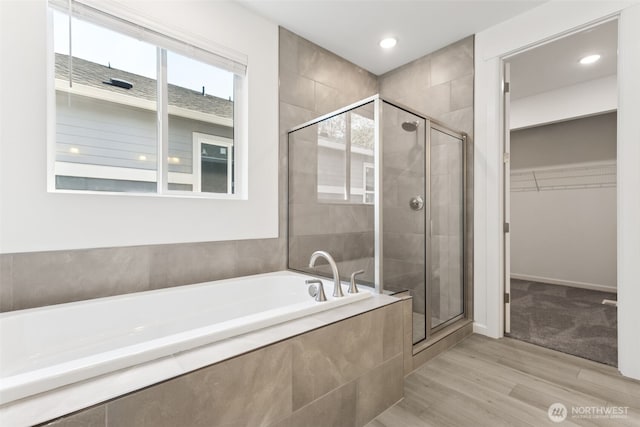 20519 97th Ave E Unit 26, Graham, WA 98338 - full bath featuring a stall shower, a garden tub, a walk in closet, wood finished floors, and recessed lighting