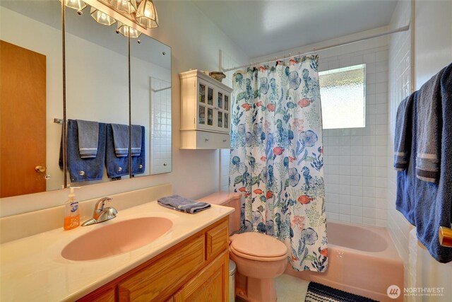 bathroom with toilet, shower / bath combination with curtain, and vanity