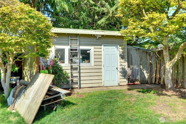 view of outbuilding with fence and an outbuilding