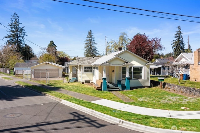 bungalow featuring an outdoor structure, a front yard, covered porch, and a garage
