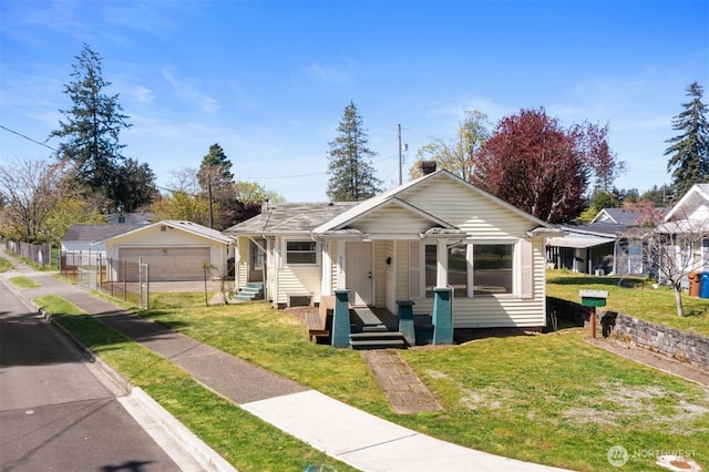 bungalow-style home with a detached garage, a porch, and a front yard