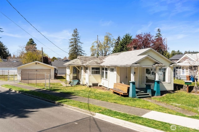 view of front facade with a porch, an outbuilding, a detached garage, and a front yard