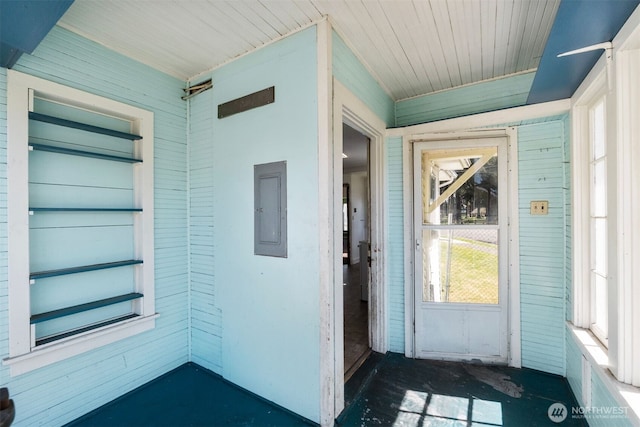 view of exterior entry featuring electric panel and a porch