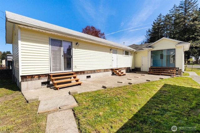 back of property with a lawn, entry steps, and a patio