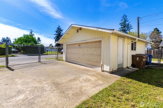 detached garage featuring fence and a gate