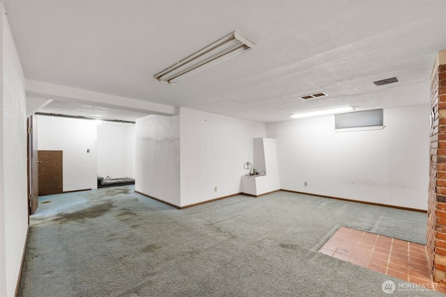 finished basement with carpet floors, visible vents, and baseboards