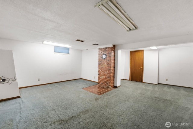 finished basement with carpet, visible vents, and baseboards