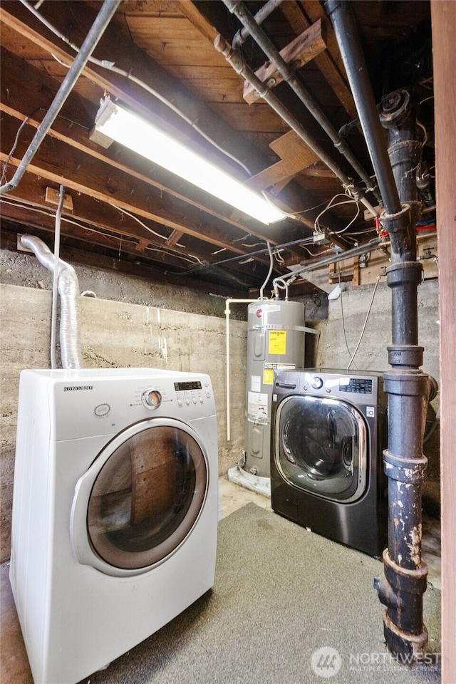 clothes washing area with strapped water heater, washer and clothes dryer, and laundry area