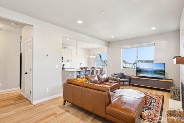 living room featuring recessed lighting, light wood finished floors, and baseboards