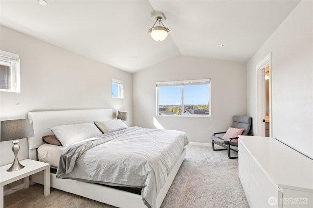 bedroom featuring baseboards, lofted ceiling, and light colored carpet
