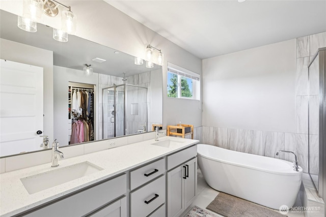 bathroom featuring a soaking tub, a sink, double vanity, and a stall shower