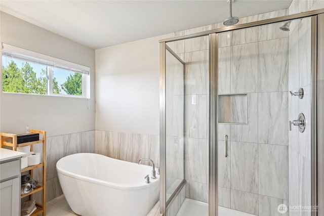 full bathroom with a freestanding tub and a shower stall