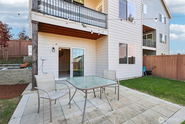 back of property featuring a patio area, a fenced backyard, and a balcony