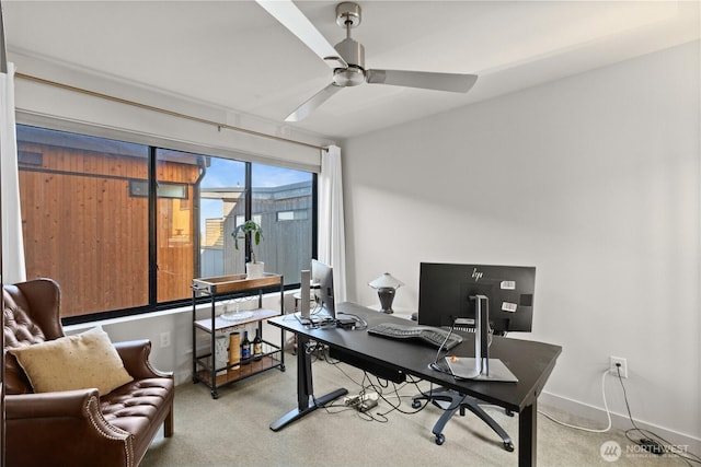office space featuring light carpet, ceiling fan, and baseboards