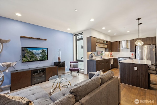 living area featuring light wood finished floors, plenty of natural light, and recessed lighting