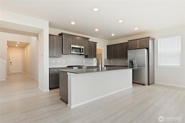 13509 197th St E, Graham, WA 98338 - kitchen featuring appliances with stainless steel finishes, a sink, backsplash, light wood-style flooring, and dark brown cabinets