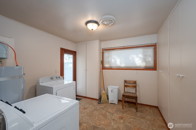 clothes washing area with water heater, washer and clothes dryer, and laundry area
