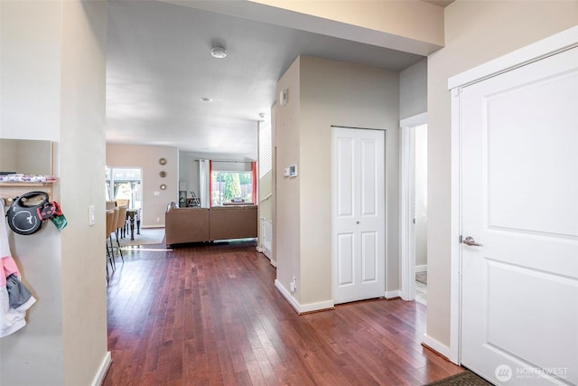 hallway with baseboards and dark wood-style floors