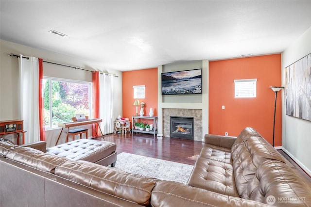living area with a fireplace, wood finished floors, and visible vents